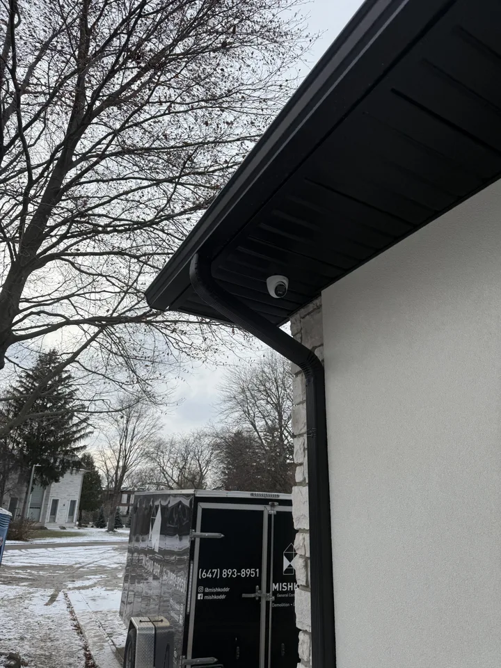 Concealed security wiring — black CCTV camera flush-mounted in soffit with zero visible cables, Toronto installation